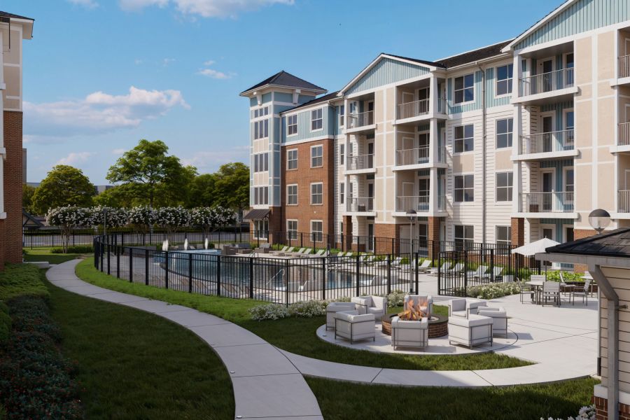 Attain at Greenbrier apartment homes with Modern apartment complex with a pool, outdoor seating, fire pit, and landscaped pathways on a sunny day.