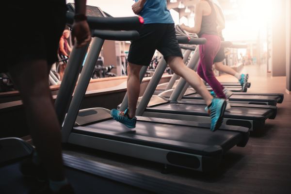 Attain on 5th apartment homes with People running on treadmills at a gym, wearing athletic clothes and sneakers, with exercise equipment in the background.