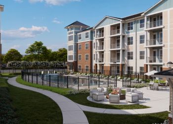 Attain on 5th apartment homes with Modern apartment complex with a pool, outdoor seating, fire pit, and landscaped pathways on a sunny day.